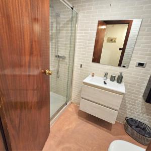 a bathroom with a shower and a sink and a mirror at Els Terrers Sun Flat in Benicàssim