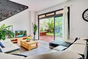 a living room with white furniture and a large window at La Villa du Patio Parenthèse familiale Piscine 4 in Saint-Pierre