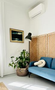 a living room with a blue couch and a plant at Jardin Rooms in Split