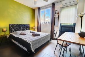 a bedroom with a bed and a table and a dining room at La Villa du Patio Parenthèse familiale Piscine 4 in Saint-Pierre +28 photos