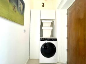 a washer and dryer in a room with a refrigerator at Studio de charme bien equipé - Matelas de qualité - Proche de la gare et de Versailles in Marly-le-Roi