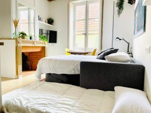 dwa łóżka w pokoju z kominkiem w obiekcie Studio de charme bien equipé - Matelas de qualité - Proche de la gare et de Versailles w mieście Marly-le-Roi