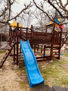 um parque infantil com um escorrega azul num parque em Leaganul Bucovinei Guest House em Suceava