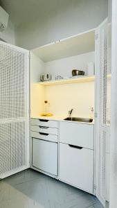 a kitchen with white cabinets and a sink at Jardin Rooms in Split