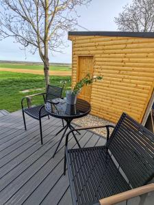 un patio con 2 sillas y una mesa en una terraza en Woody en Szigetvár