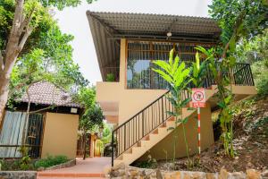 a house with a staircase leading up to it at Khu du lịch Suối Ong in Buôn Erang