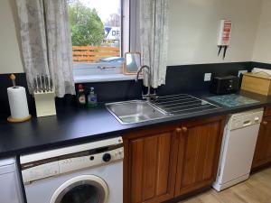 a kitchen counter with a sink and a dishwasher at Springwell Cottage in Fort William