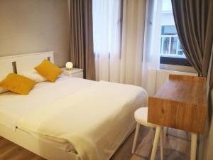 1 dormitorio con 1 cama, escritorio y ventana en Great Location, Modern 1BR at the heart of Taksim, en Estambul