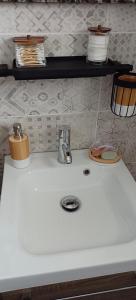 uma bancada branca com um lavatório na cozinha em chambre d'hôte La Paisible em Treize-Vents
