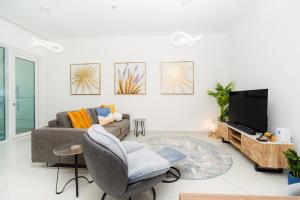 a living room with a couch and a tv at Dubai Marina - 1BHK Apartment in Dubai