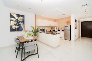 a kitchen with a table and a refrigerator at Dubai Marina - 1BHK Apartment in Dubai