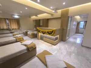 a large room with two beds and a couch at Raman Dormitory in Navi Mumbai +32 photos