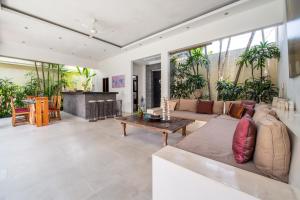 a living room with a couch and a table at Villa Minha Gente Seminyak in Seminyak