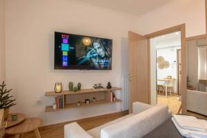 a living room with a white couch and a tv on the wall at Iris luxury apartment in Athens