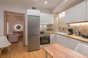 a kitchen with white cabinets and white appliances at Iris luxury apartment in Athens
