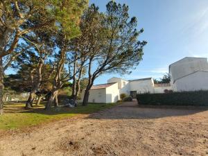 a house with trees and a dirt road at Studio 2 à 4 personnes proche de la plage in La Guérinière