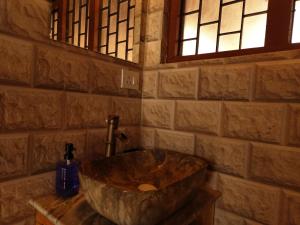 y baño con lavabo grande de piedra en una pared de ladrillo. en TSUKIMI Homestay, Naggar, Manali, en Nagar