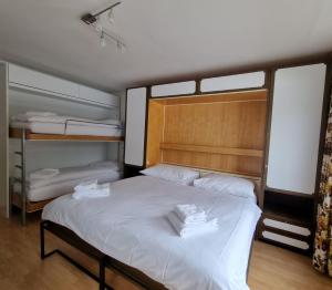 een slaapkamer met een bed en 2 stapelbedden bij Holiday flat for skiing couples Triangel D - Parpan Lenzerheide in Parpan