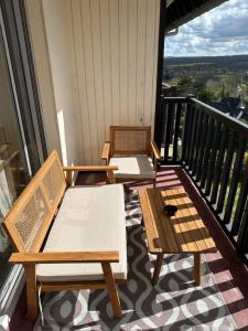 2 bancos en un balcón con vistas en Appartement terrasse vue mer/campagne, en Blonville-sur-Mer