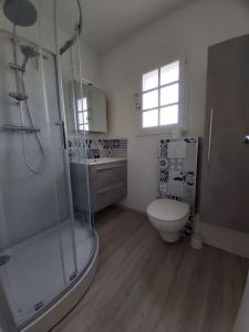 a bathroom with a shower and a toilet and a sink at Studio 4 pers. bord de plage in La Guérinière