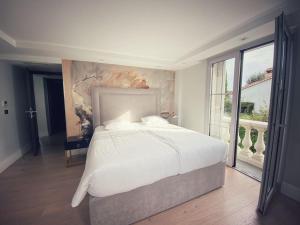 ein Schlafzimmer mit einem großen Bett und einem großen Fenster in der Unterkunft Cannes, perfect holiday villa with heated pool in Le Cannet