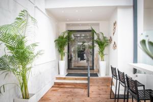 un couloir avec des plantes en pot dans un bâtiment dans l'établissement Celia Residence, à Athènes