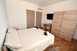 1 dormitorio con cama blanca y armario de madera en Adria bnb, en Adria