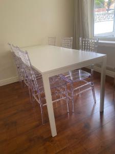 uma mesa de jantar branca com cadeiras à volta em Spacious 3 Bed House in Penrhyn Bay Llandudno em Llandudno
