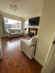 uma sala de estar com dois sofás brancos e uma lareira em Spacious 3 Bed House in Penrhyn Bay Llandudno em Llandudno