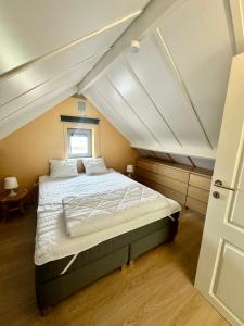 um quarto com uma cama grande num sótão em Zeepark Mercator em Wenduine