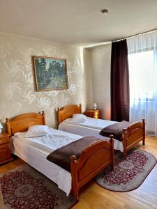 - une chambre avec 2 lits et un tableau mural dans l'établissement Panoramic Cetatuie, à Cluj-Napoca