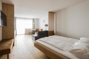 ein Schlafzimmer mit einem Bett und ein Wohnzimmer in der Unterkunft Hotel & Residence Rebhof in Dorf Tirol