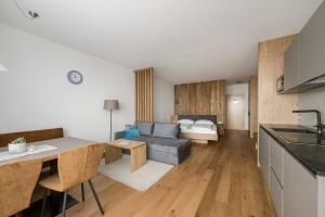 a kitchen and a living room with a couch at Hotel & Residence Rebhof in Tirolo