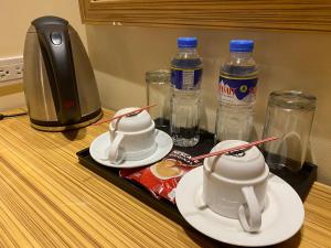 uma bandeja com duas chávenas e garrafas de água em Sun Star Grand Hotel em Manila