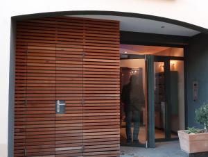 a man is standing in front of a wooden door at Appartement climatisé 50m2 centre du village in Porquerolles