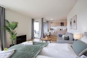 1 dormitorio con 1 cama y sala de estar en STAYY Sky Studio near Limmattal Hospital - contactless check-in, en Schlieren