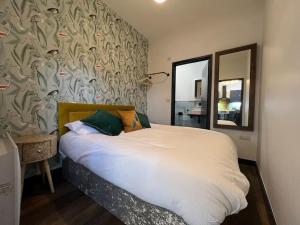 a bedroom with a white bed with a wall with a mirror at Marina Studio in Gosport