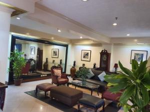 馬尼拉的住宿－Stone House Quezon City，带沙发、椅子和时钟的客厅