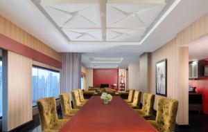 a conference room with a long table and chairs at Manhattan Hotel Jakarta in Jakarta