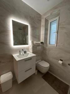 a white bathroom with a toilet and a sink at Perina Apartment - free parking in Dubrovnik