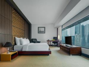 Habitación de hotel con cama y ventana grande en Manhattan Hotel Jakarta, en Yakarta