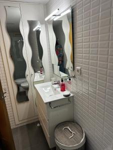 a bathroom with a toilet and a sink and mirrors at ALOJAMIENTO SARDOY in Murcia