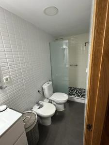 a white bathroom with two toilets and a shower at ALOJAMIENTO SARDOY in Murcia