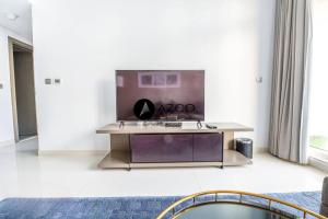 - un salon avec une table et une télévision dans l'établissement Fabulous luxurious 2BR in Damac Maison Prive, à Dubaï