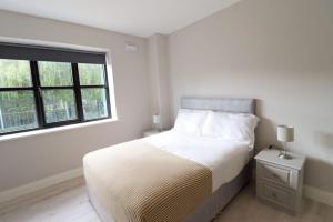 biała sypialnia z łóżkiem i oknem w obiekcie Inviting 2-Bed Apartment in Dublin w Dublinie