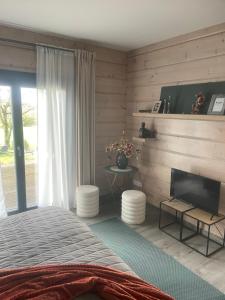 - une chambre avec un lit et une télévision à écran plat dans l'établissement Un petit îlot de confort - made in Finland, à Monflanquin