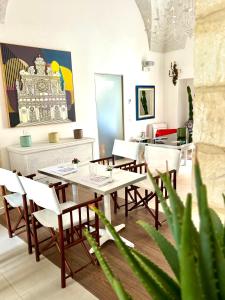 una sala da pranzo con tavoli e sedie bianchi di Palazzo Cavour a Lecce