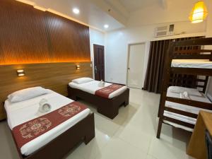 een kamer met 2 bedden en een paar stapelbedden bij Stone House Quezon City in Manilla