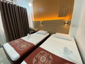 two beds in a small room with a window at Stone House Quezon City in Manila +65 photos