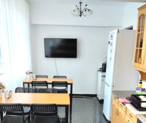 a kitchen with a table and chairs and a refrigerator at Like Home Guest Rooms in Almaty